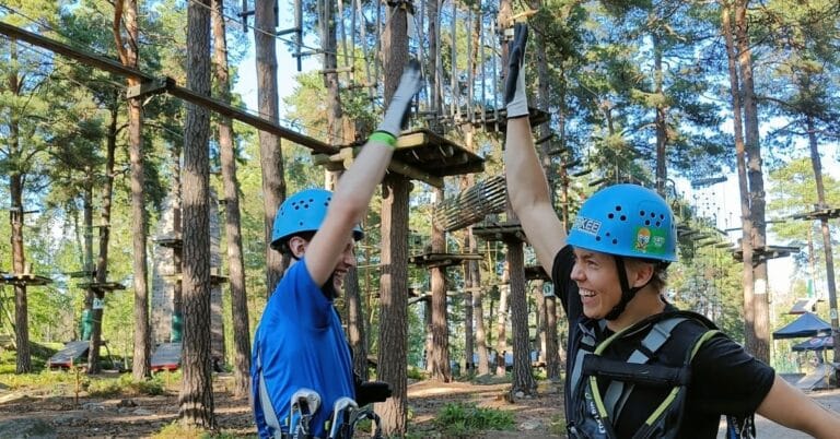 Oppilaat antavat ylävitosia ja hymyilevät yhdessä retkipäivän aktiviteetin jälkeen
