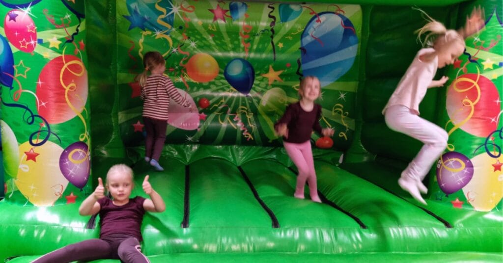 Neljä lasta pomppimassa pomppulinnassa