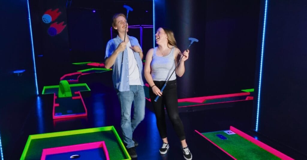 Kaksi nuorta aikuista iloisissa tunnelmissa Hohtogolfissa